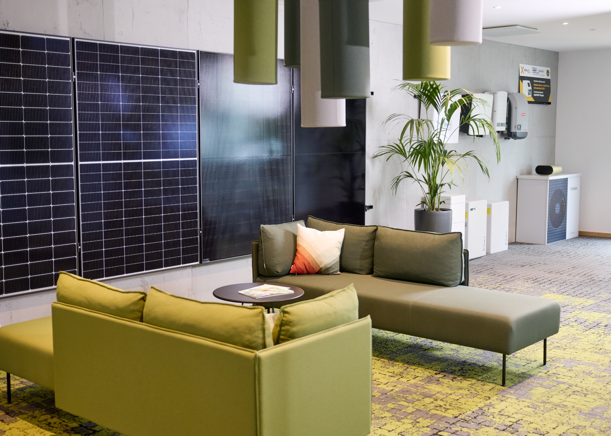 Unser Showroom mit Sitzbereich, Photovoltaikmodulen, Stromspeichern und Wärmepumpe