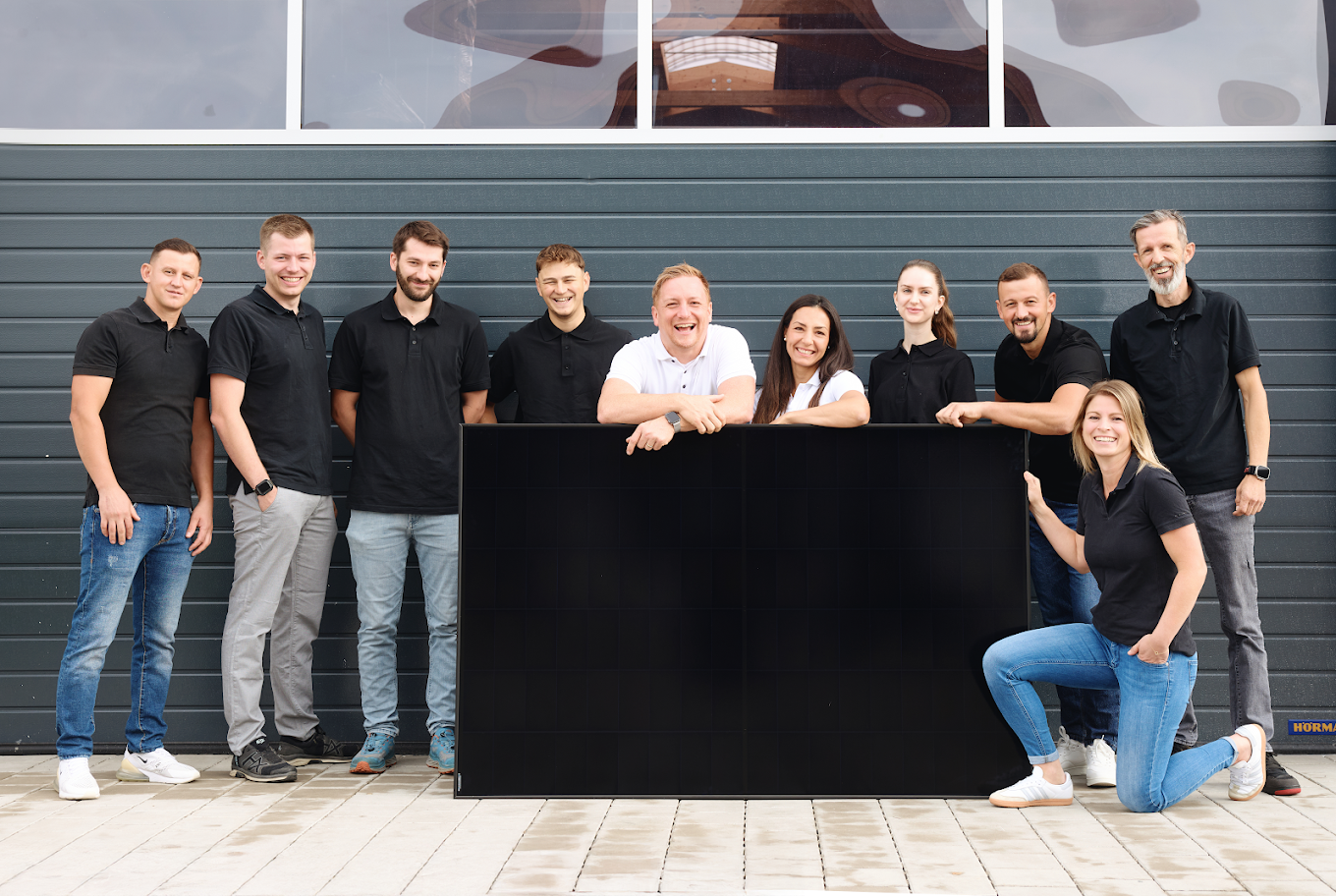 Das Team von Hirschberger Energietechnik mit einem Photovoltaikmodul
