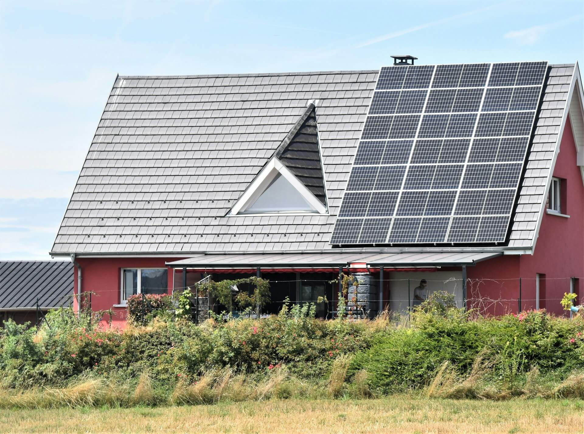 "Einfamilienhaus mit Solarpaneelen auf dem Dach, das zur Nutzung von Solarenergie geneigt ist